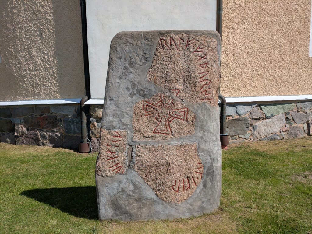 Stenen visar en runsten uppmålad med röd färg.