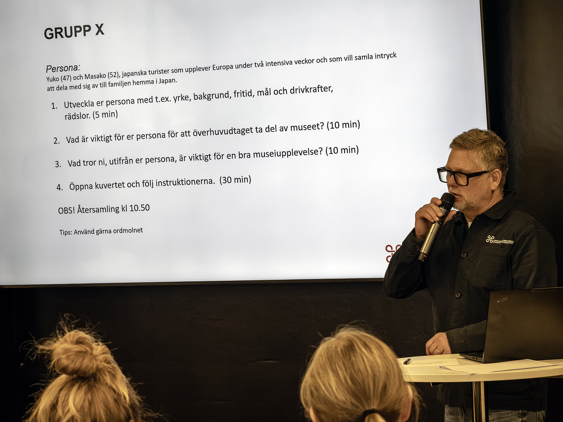 På en scen, på en projektorduk, visas förslag på en "persona" - ett japanskt par som vill uppleva så mycket som möjligt under sina två veckor i Sverige.