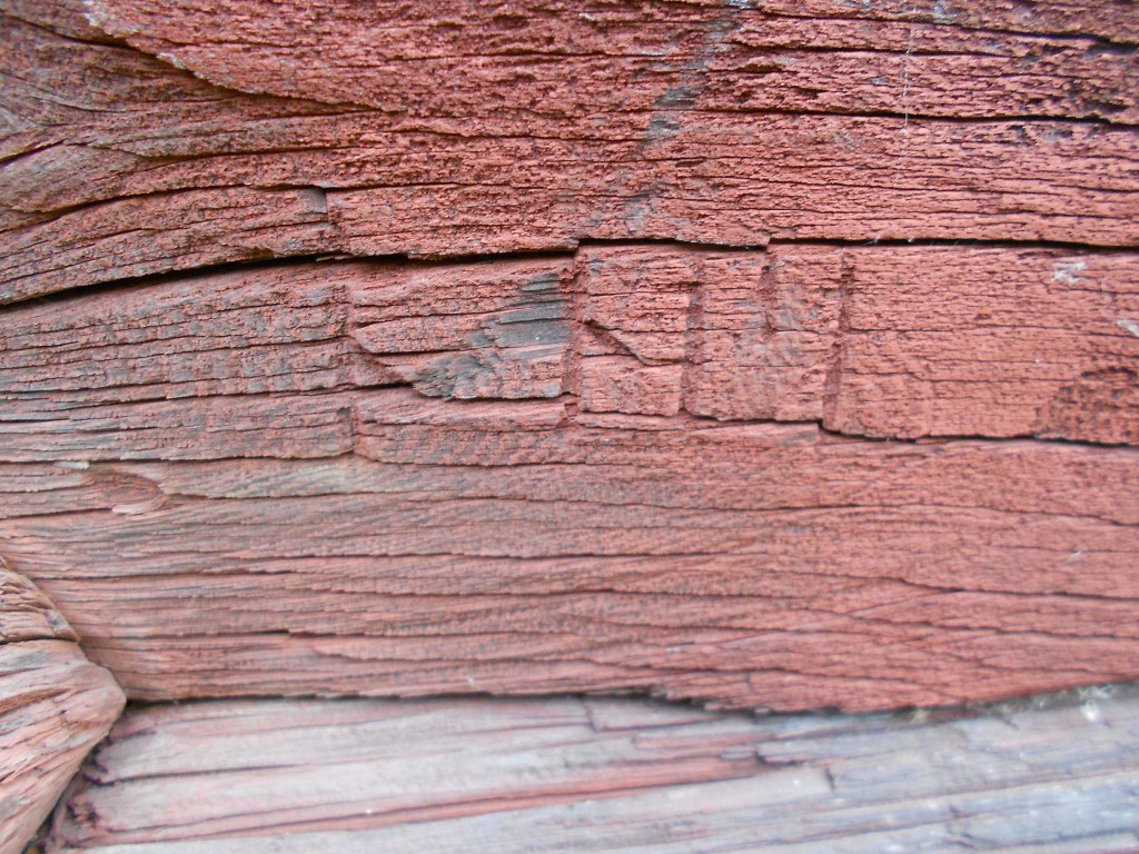 Bilden visar några runor ristade på en rödmålad vägg