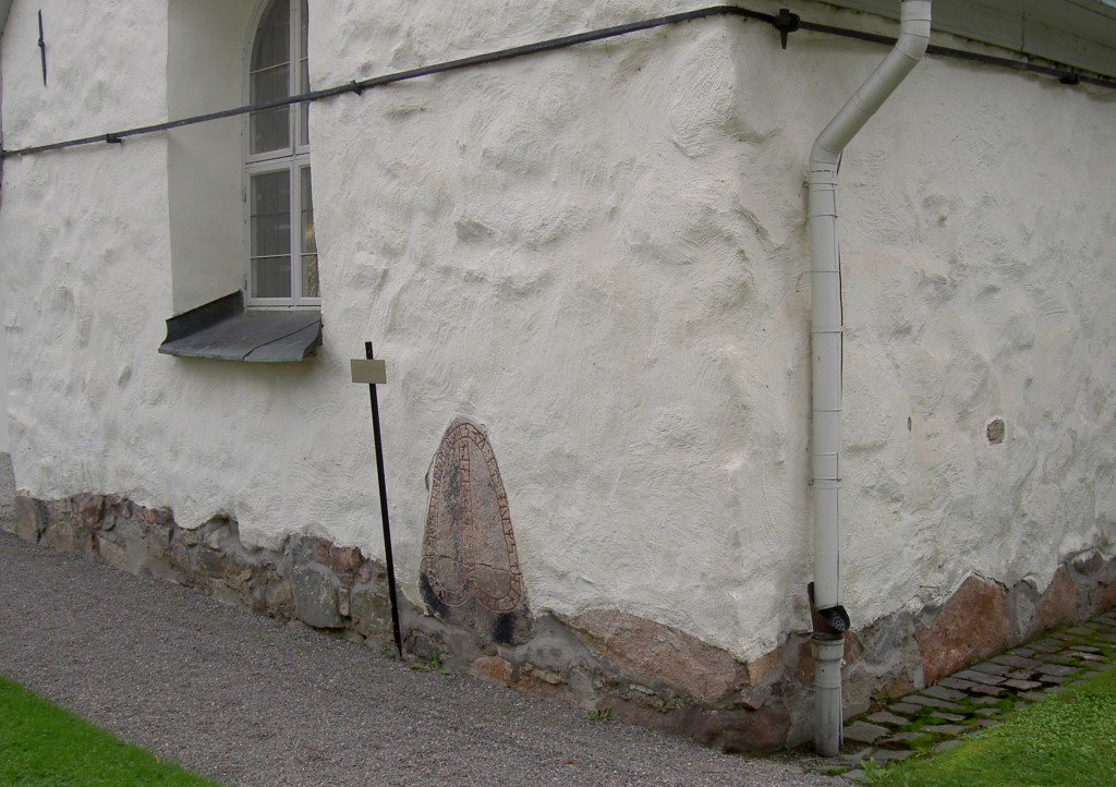 Bilden visar en runsten inmurad i en kyrkvägg