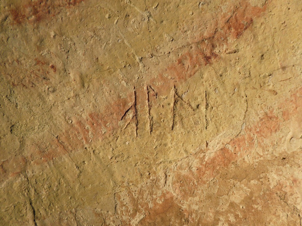 Bilden visar runor ristade i puts ovanpå en kalkmålning