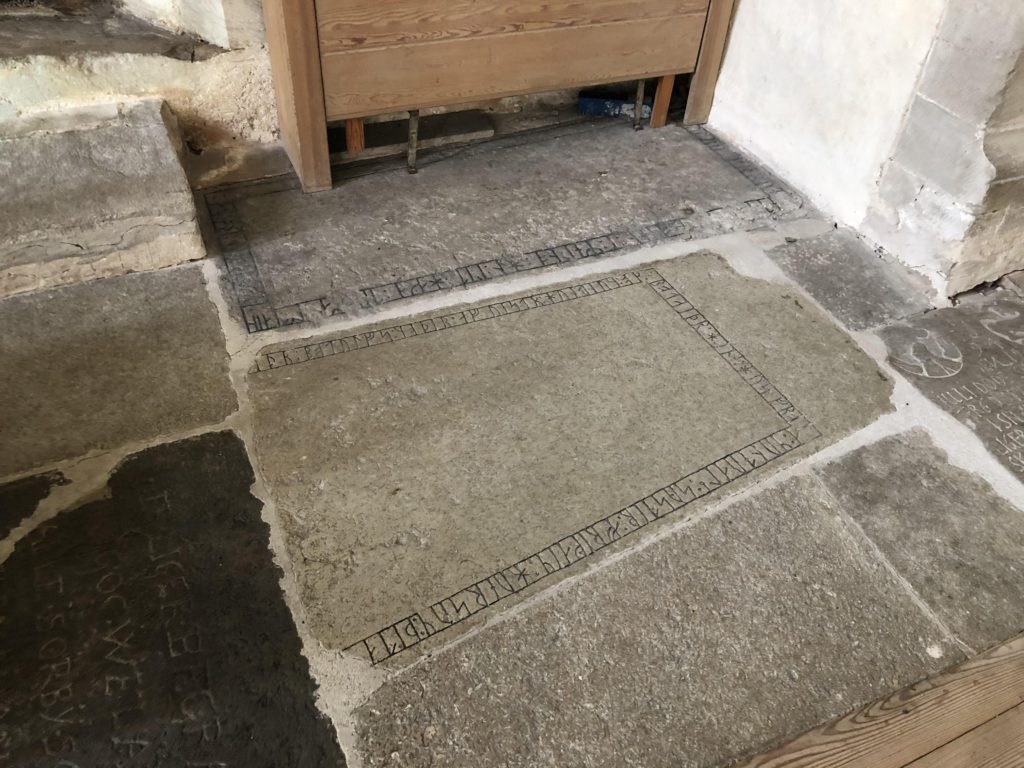 Bilden föreställer ett par gravhällar med runor inlagda i ett kyrkgolv