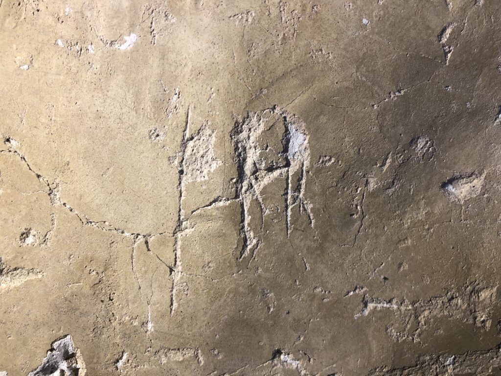 Bilden visar runor ristade på en kalkstruken vägg.