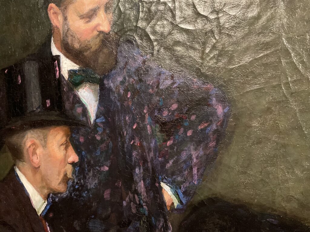 Närbild på Richard Bergs tavla där den stående och den sittande mannen i hatt syns och i bakgrunden syns den krackelerade färgbakgrunden.