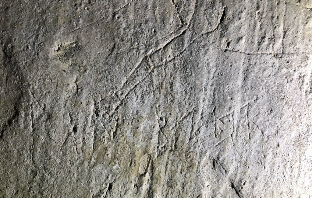Bilden visar en rad med runor ristade i puts.